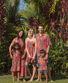 family wearing a colorful matching set with tropical lei printing
