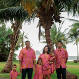 family wearing matching pink aloha wear with lei print