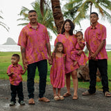 family wearing matching pink aloha wear with lei print