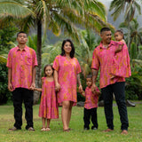 family wearing matching pink aloha wear with lei print