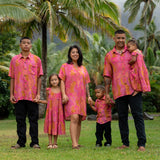 family wearing matching pink aloha wear with lei print