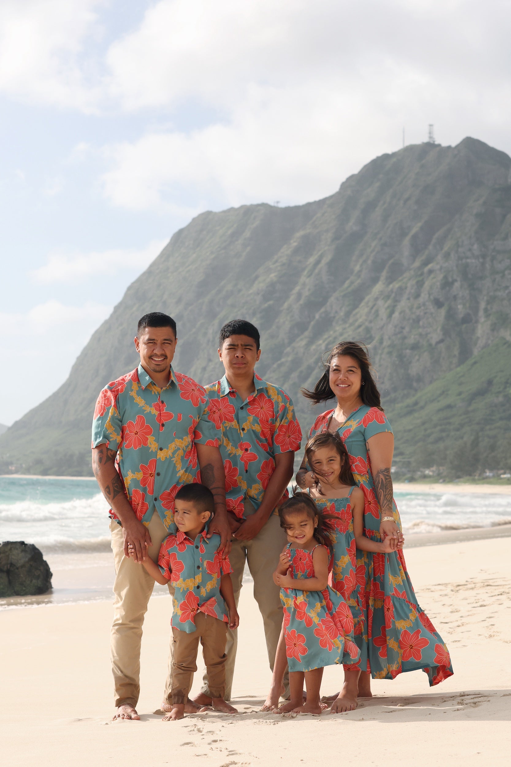 man wearing green button up shirt with orange and yellow lei pua print