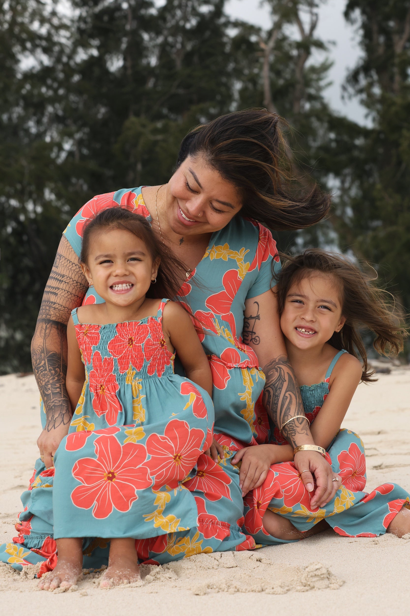 little girl wearing a green knee length dress with orange and yellow lei pua print 