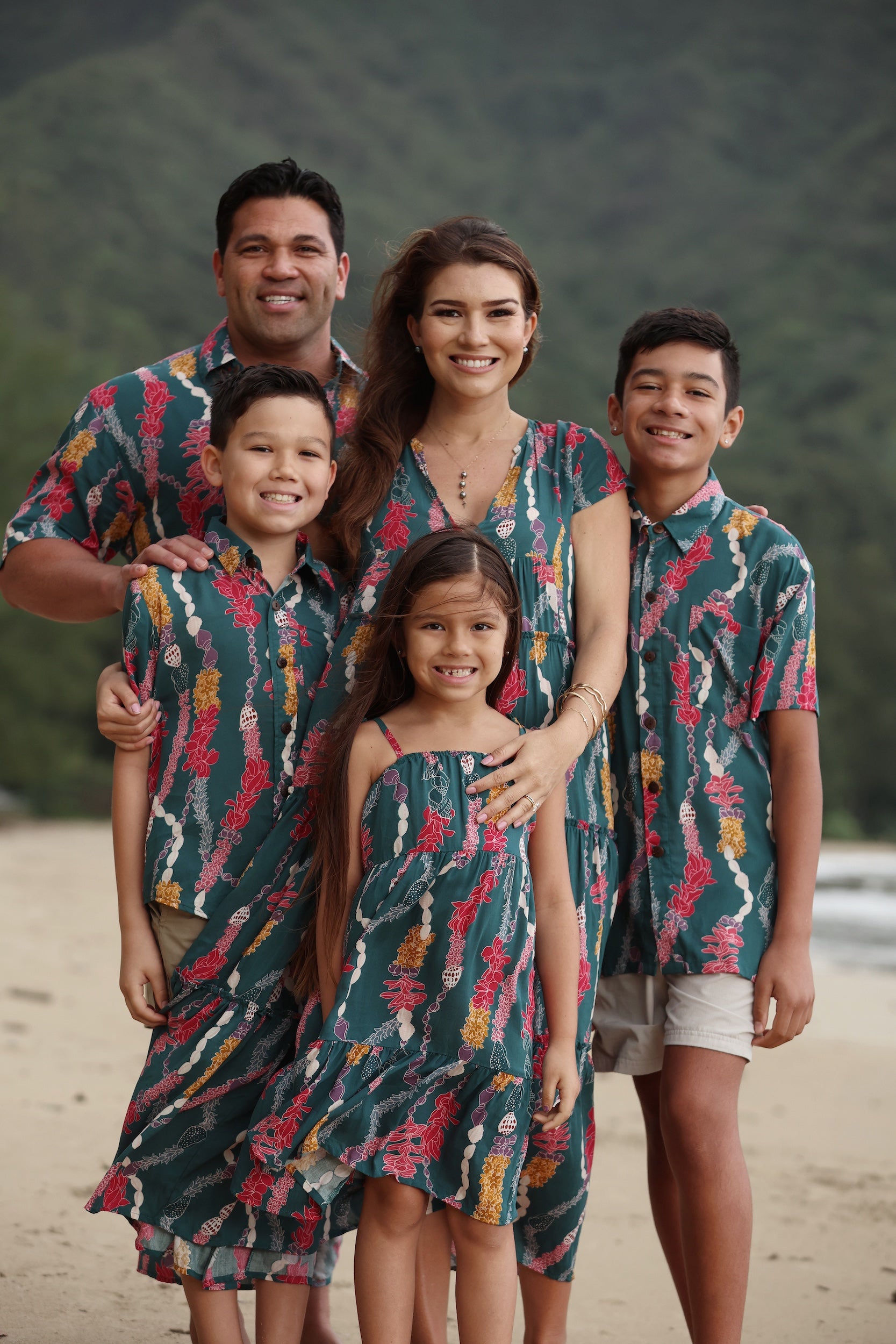 little girl wearing a knee length dress with tie spaghetti straps in dark teal with shell and lei print