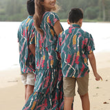 little boy wearing aloha button up shirt in dark teal with shell and lei print