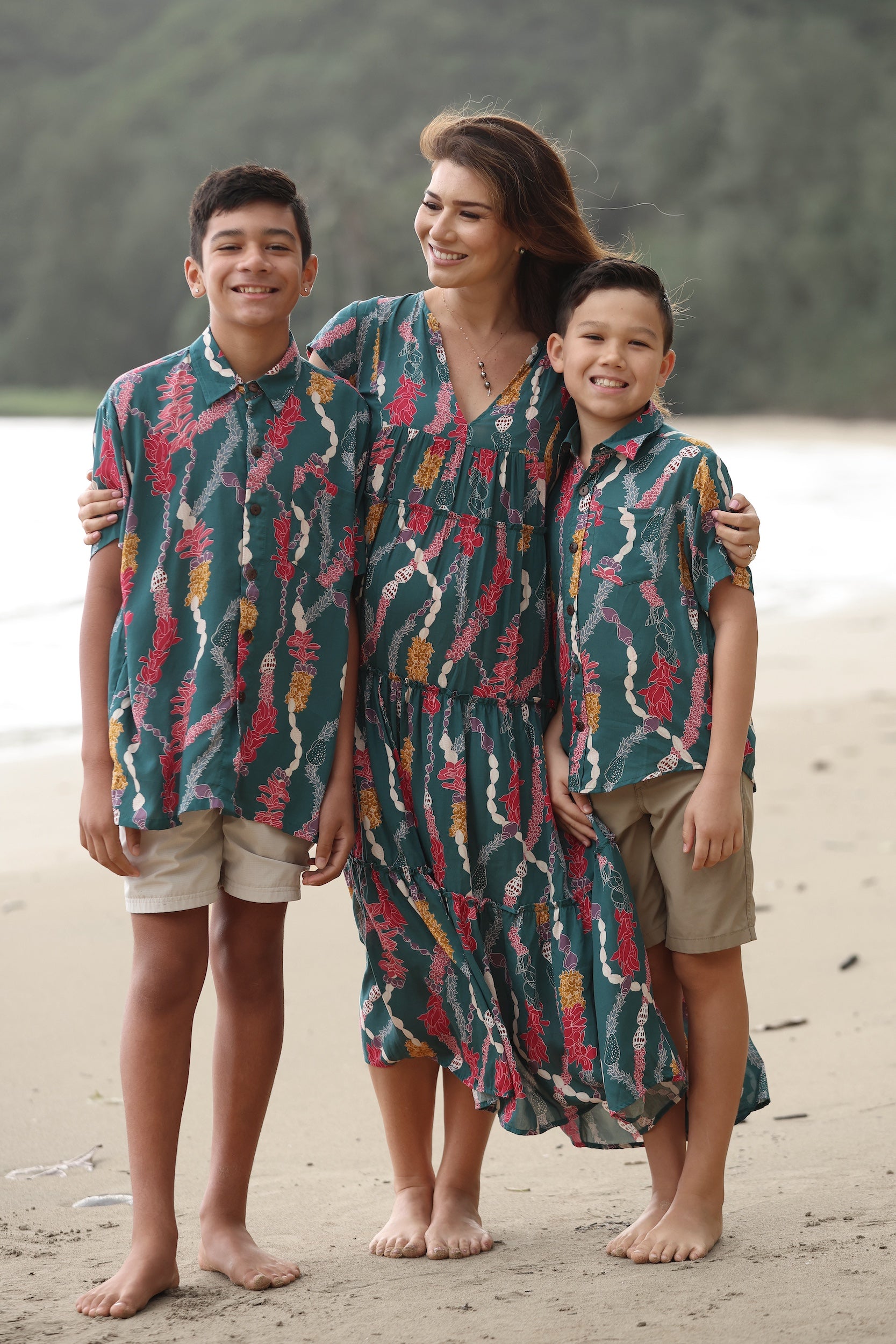 little boy wearing aloha button up shirt in dark teal with shell and lei print