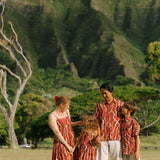 boy wearing red-brown aloha button up shirt with lei print