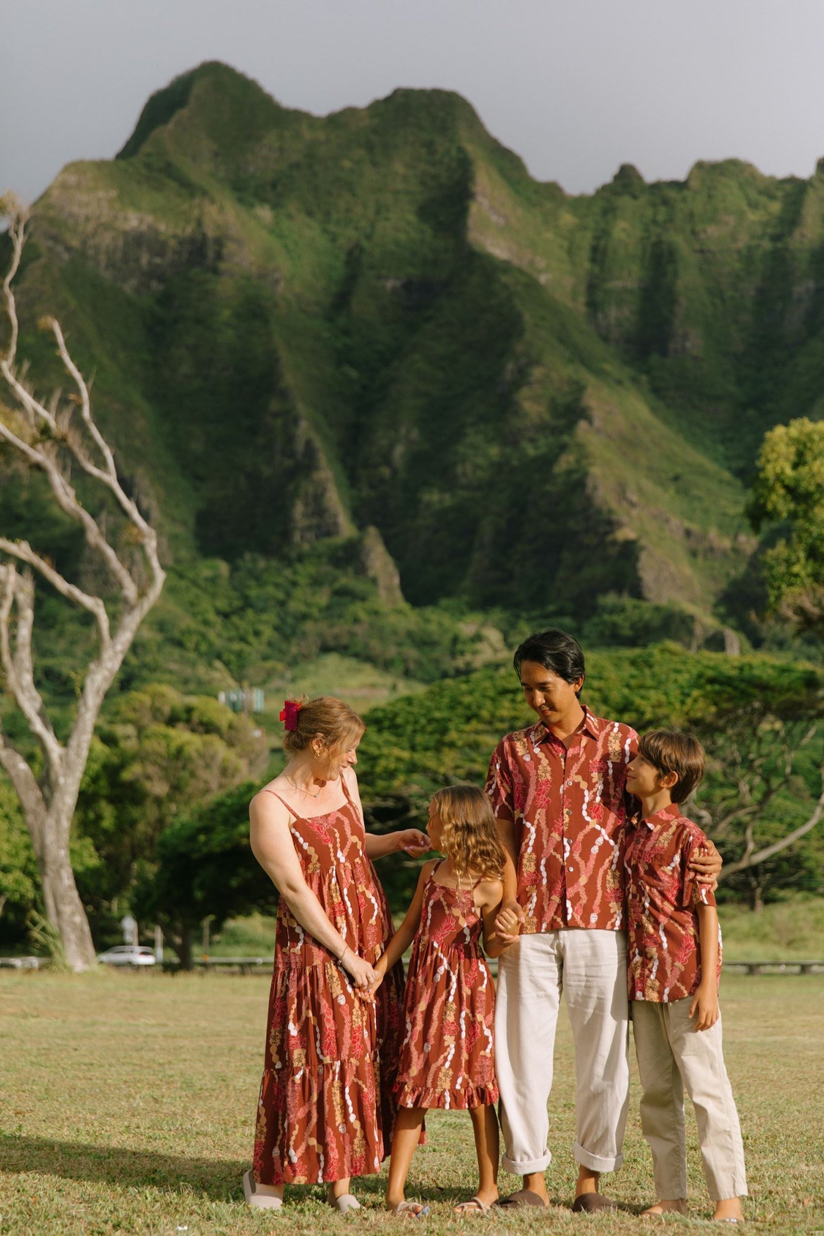 boy wearing red-brown aloha button up shirt with lei print