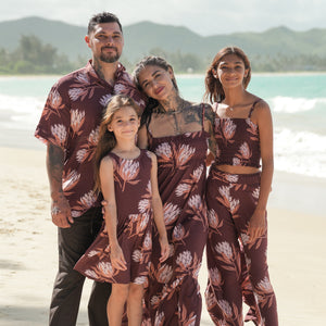 man wearing brown button up aloha shirt with protea print