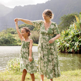 little girl wearing green smocked dress with native Hawaiian plants