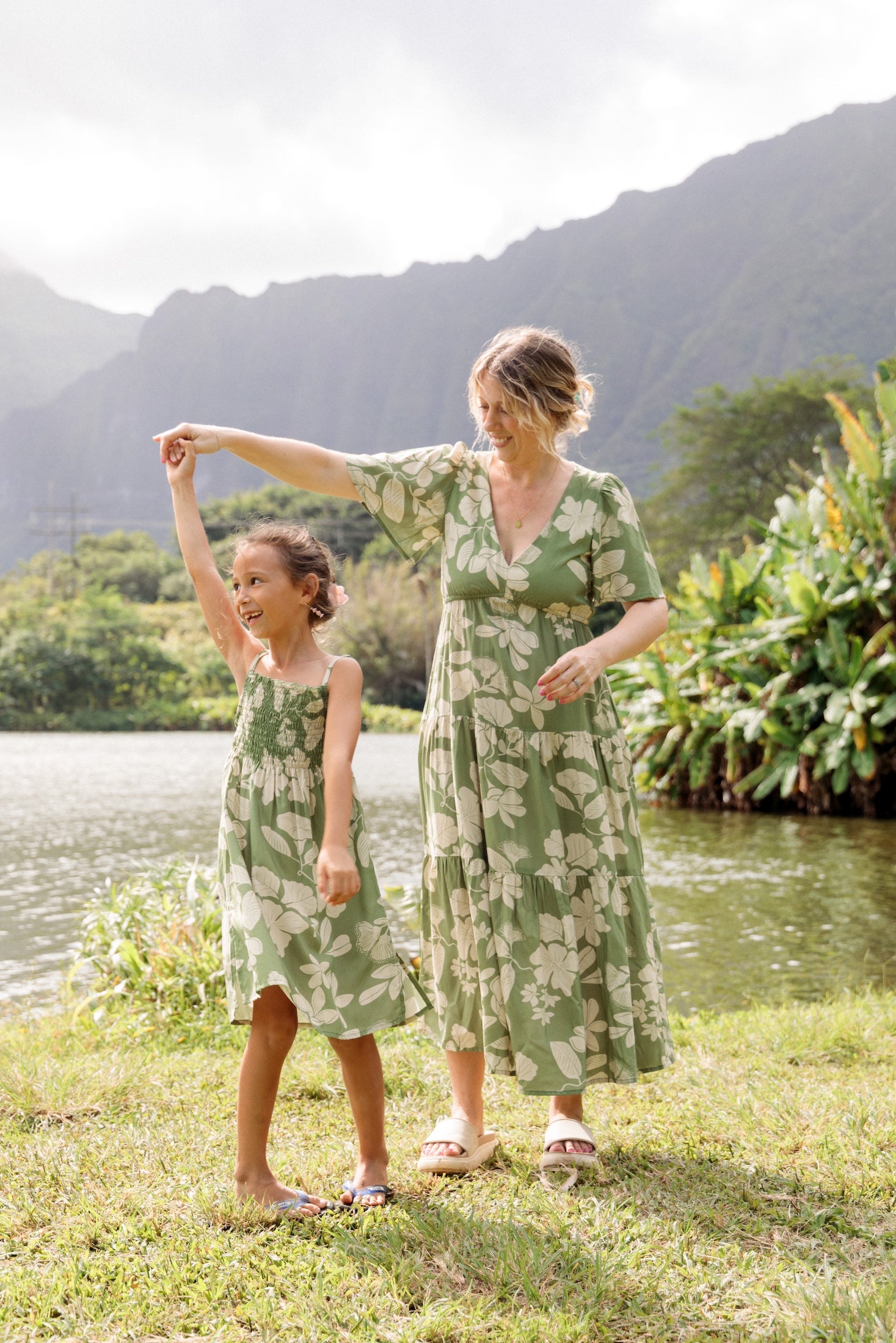 little girl wearing green smocked dress with native Hawaiian plants
