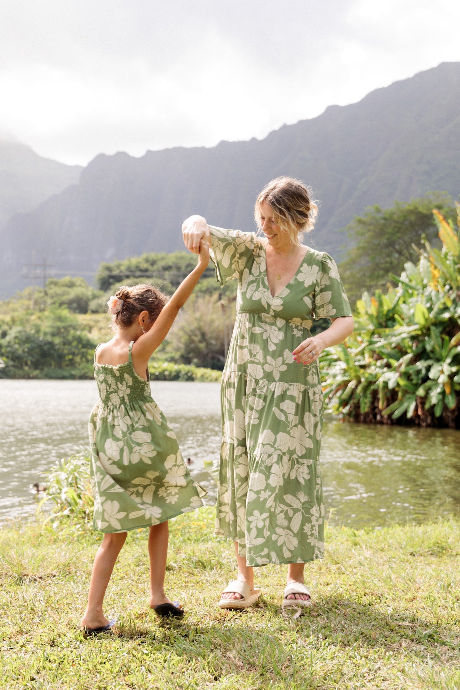 little girl wearing green smocked dress with native Hawaiian plants
