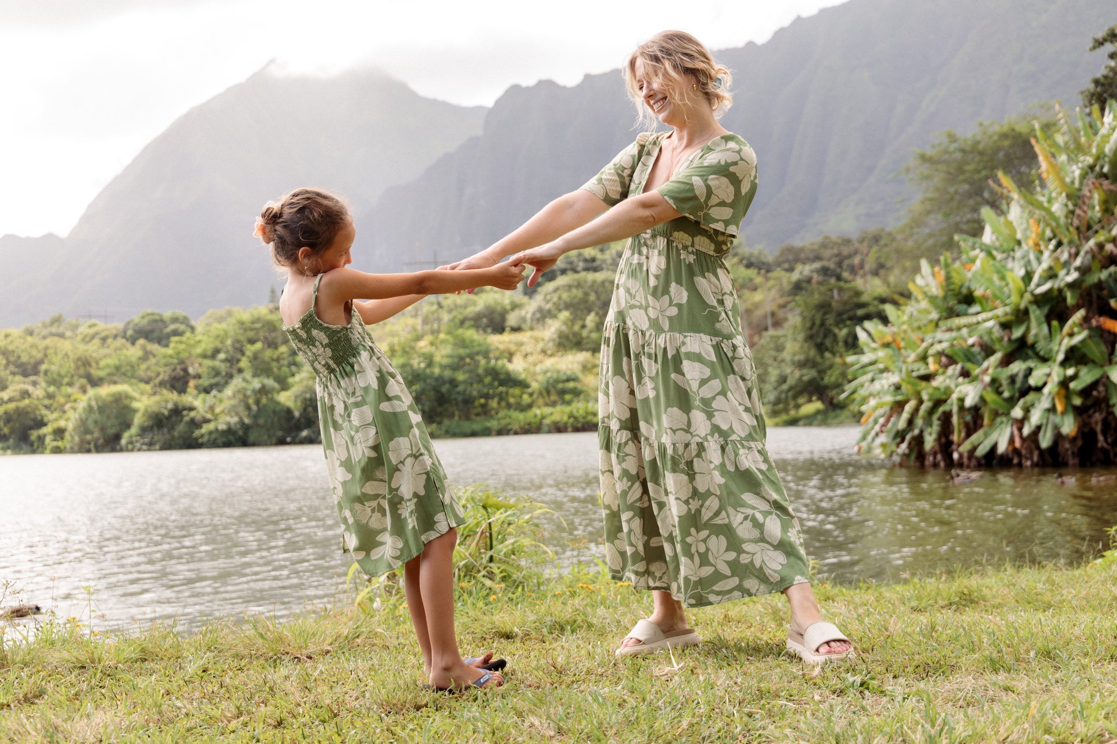 little girl wearing green smocked dress with native Hawaiian plants