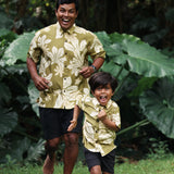 little boy wearing mini aloha button up shirt in green print and naupaka pattern