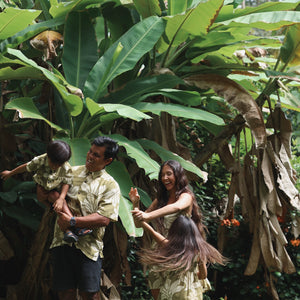family wearing matching aloha wear in green print with naupaka pattern
