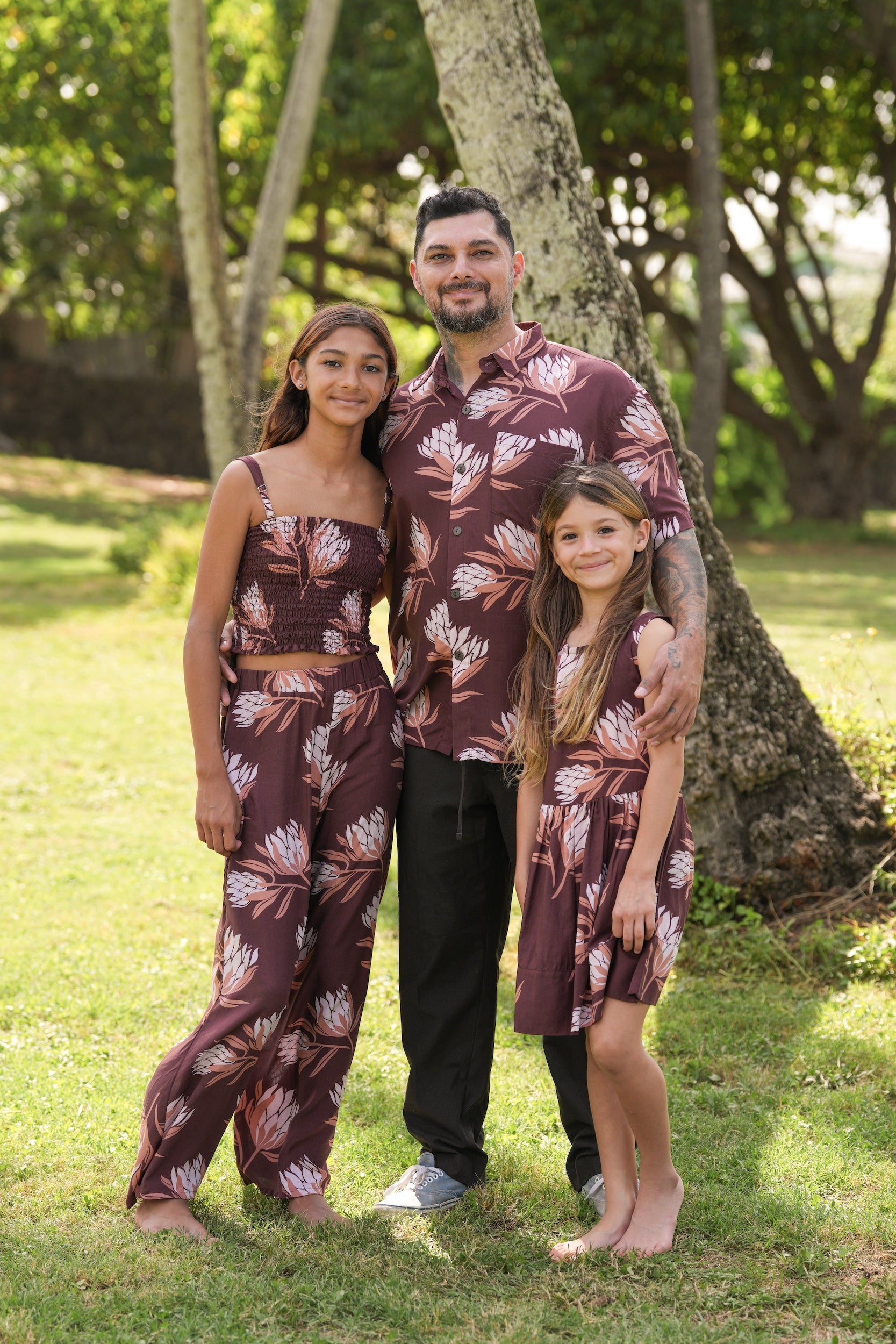 little girl wearing brown high neck, sleeveless dress with protea print