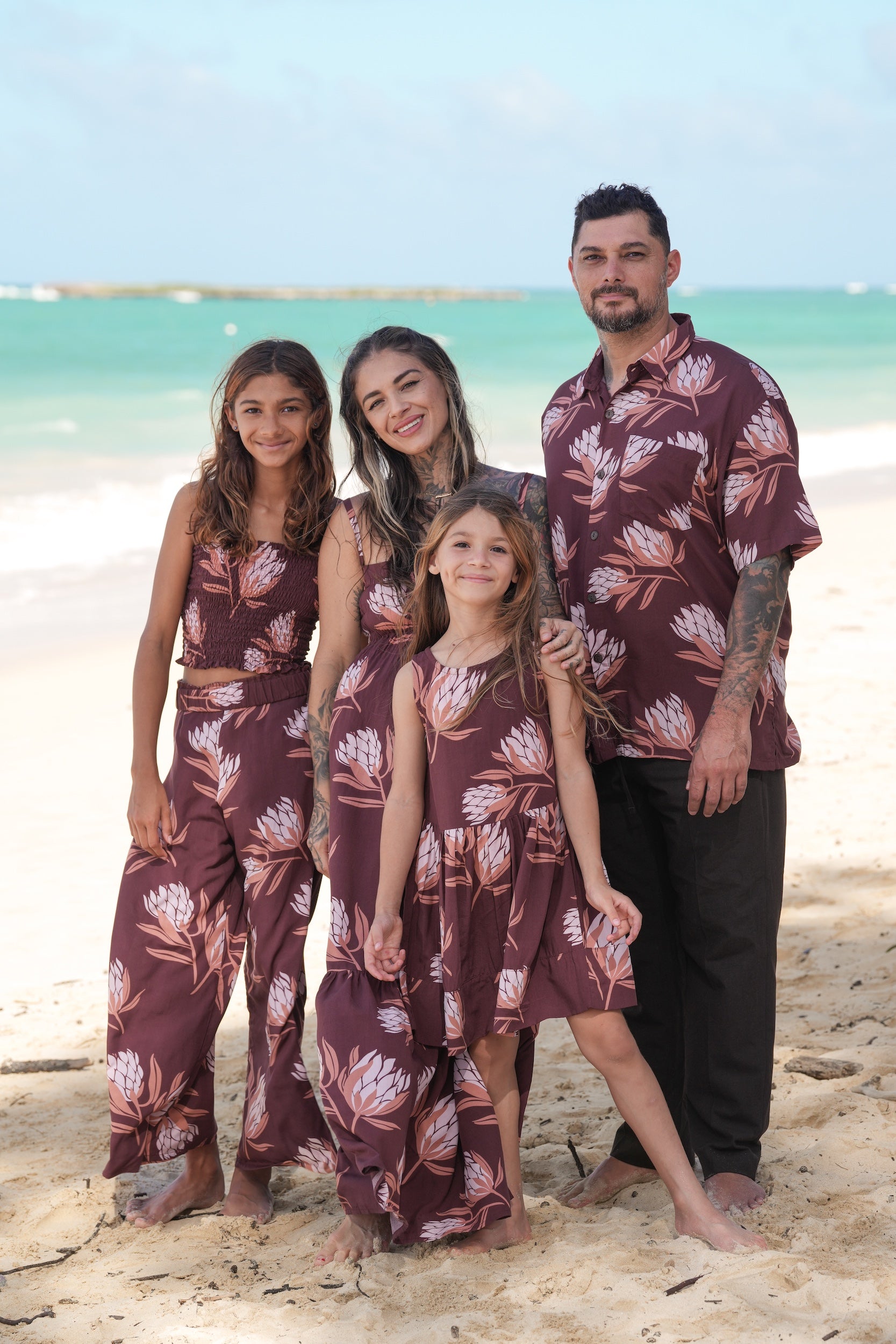 little girl wearing brown high neck, sleeveless dress with protea print
