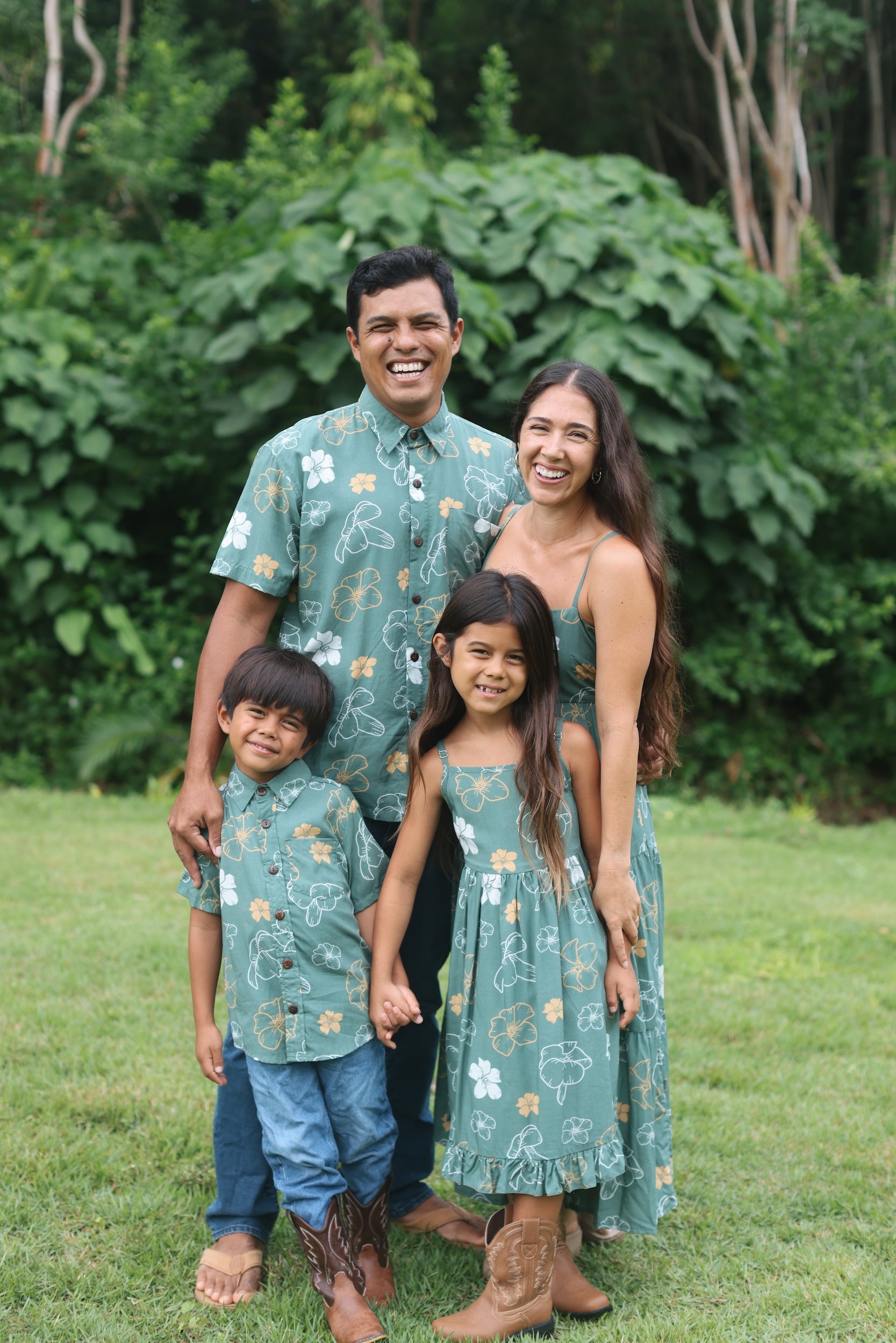 little boy wearing lush green aloha button up shirt with pua kenikeni print