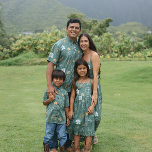 man wearing lush green aloha button-up shirt with pua kenikeni print