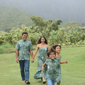 man wearing lush green aloha button-up shirt with pua kenikeni print