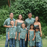 little boy wearing lush green aloha button up shirt with pua kenikeni print