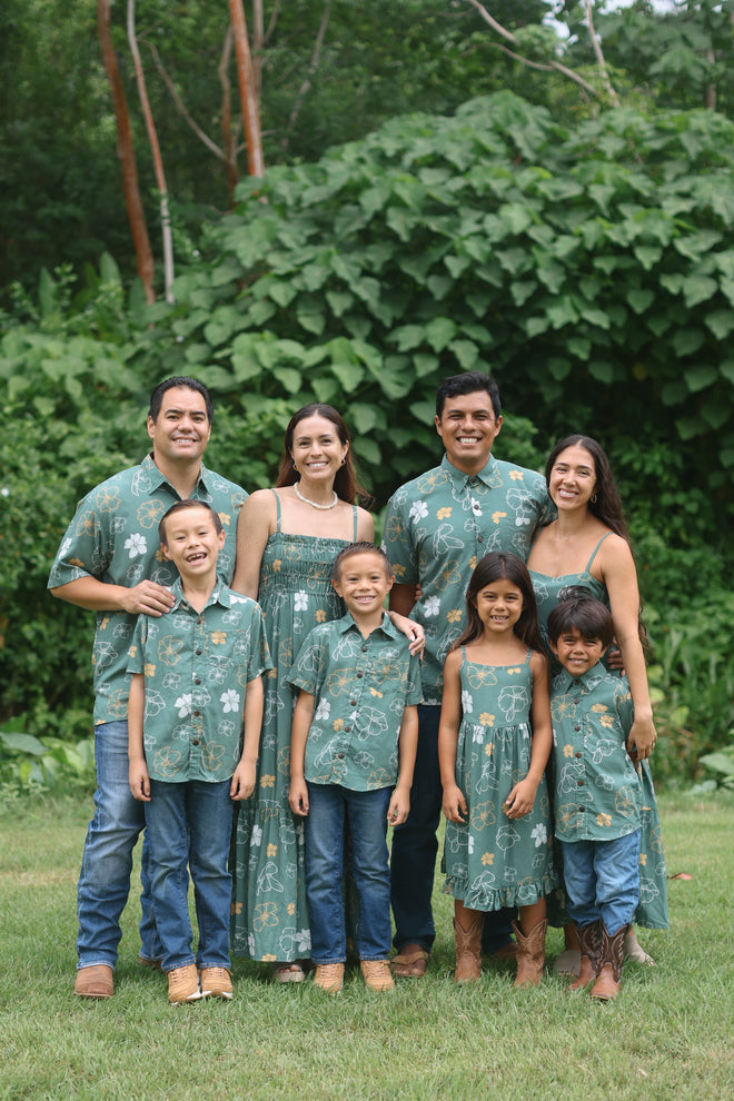 little boy wearing lush green aloha button up shirt with pua kenikeni print