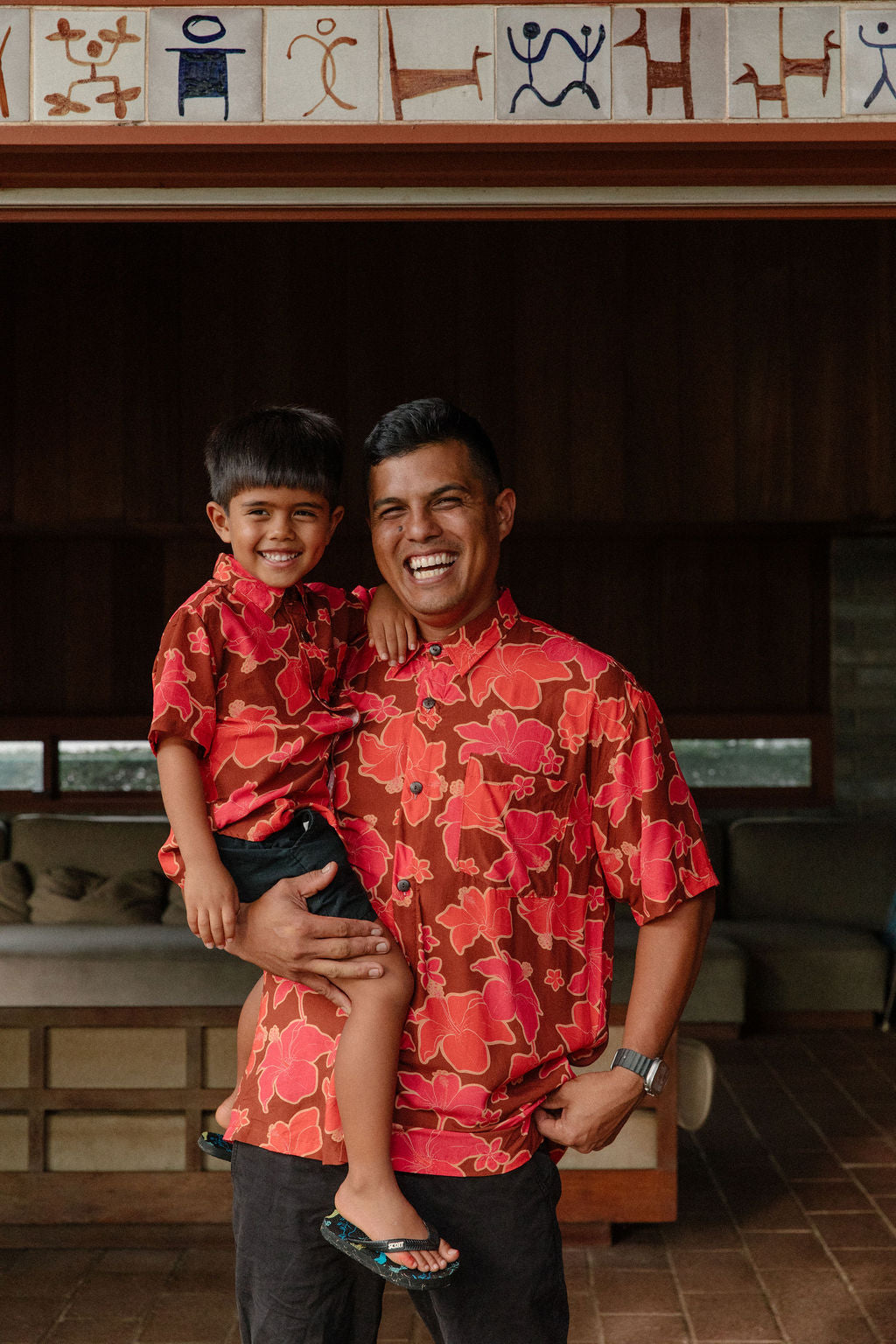 litte boy wearing aloha button up shirt with vibrant pink pua pattern