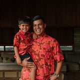 litte boy wearing aloha button up shirt with vibrant pink pua pattern