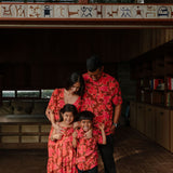 little girl wearing tie back dress with retro pink pua pattern