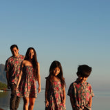 little boy wearing a teal aloha shirt with shell and pua print 