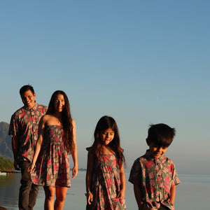 little boy wearing a teal aloha shirt with shell and pua print 