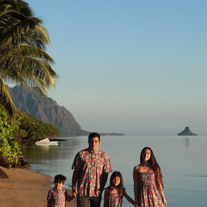 little boy wearing a teal aloha shirt with shell and pua print 