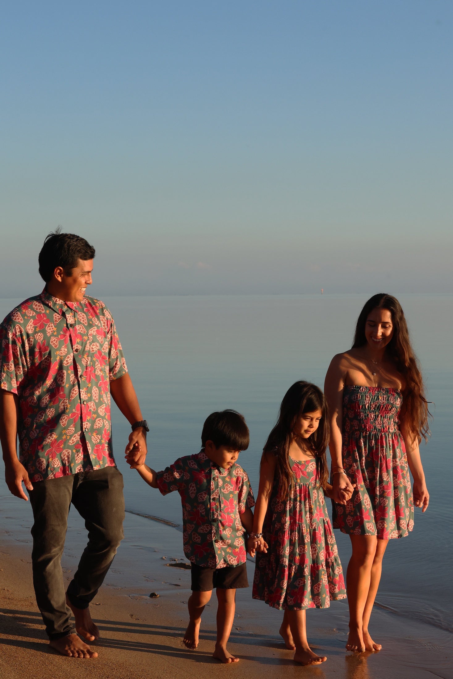 man wearing a teal aloha shirt with shell and pua print