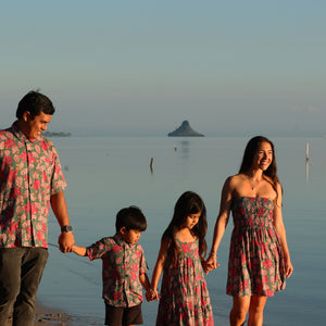 little girl wearing a teal dress with flutter sleeves with shell and pua print
