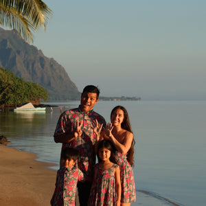 man wearing a teal aloha shirt with shell and pua print