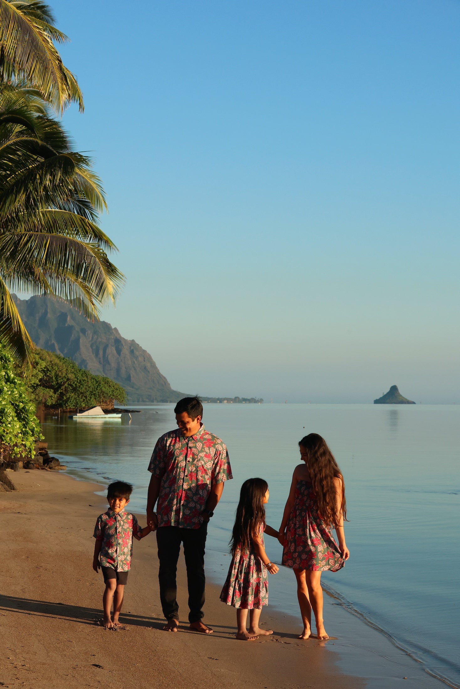 man wearing a teal aloha shirt with shell and pua print