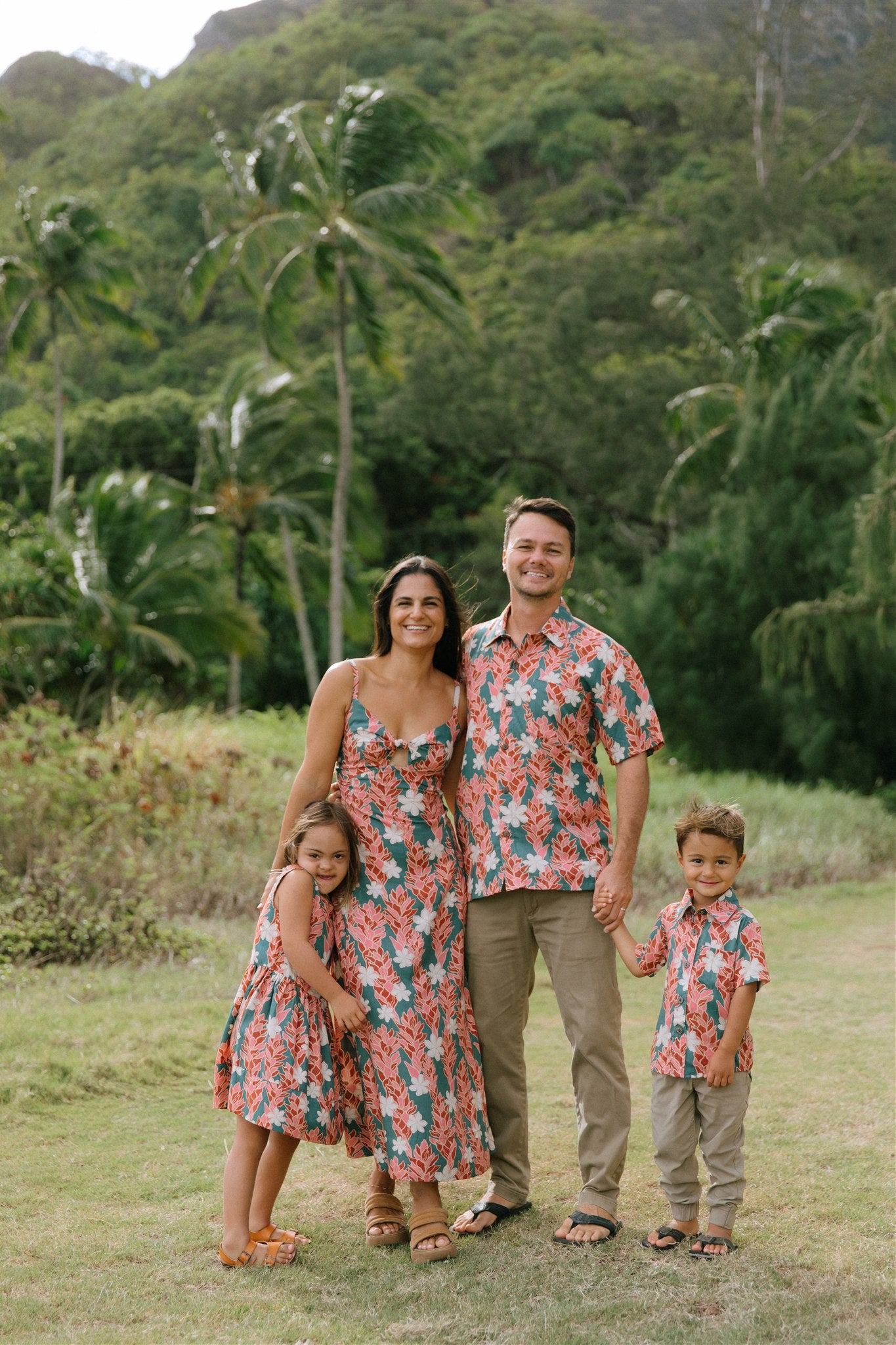 little boy wearing an aloha button up shirt with red ginger and tiare print