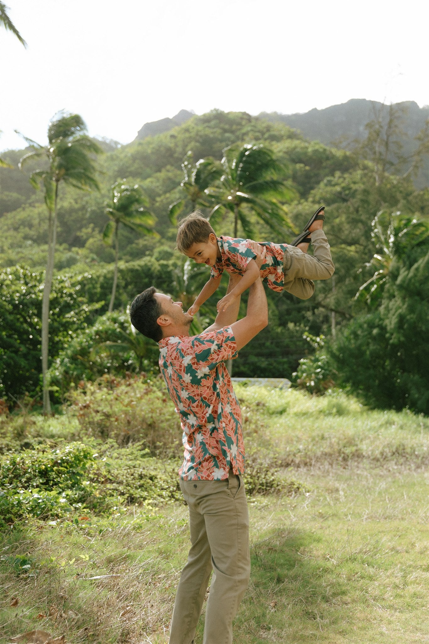 man wearing an aloha button up shirt with red ginger and tiare print