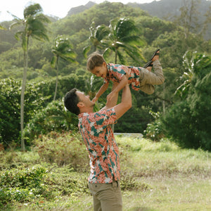 man wearing an aloha button up shirt with red ginger and tiare print