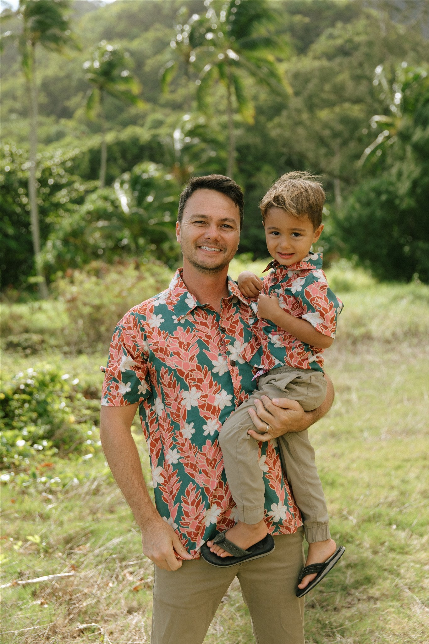 man wearing an aloha button up shirt with red ginger and tiare print