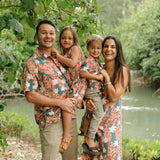 little girl wearing a knee length dress with red ginger and tiare print