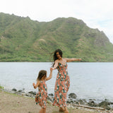 little girl wearing a knee length dress with red ginger and tiare print
