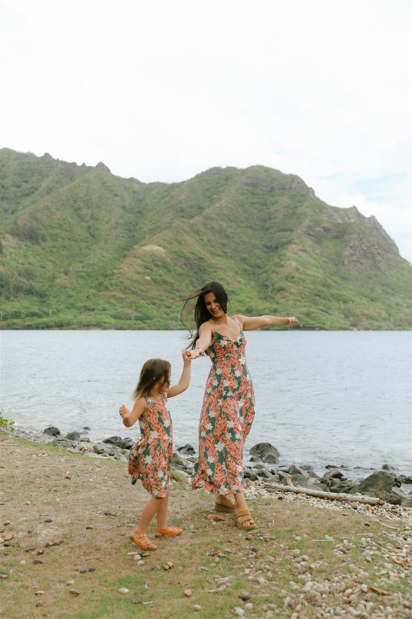 little girl wearing a knee length dress with red ginger and tiare print