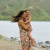 little girl wearing a knee length dress with red ginger and tiare print