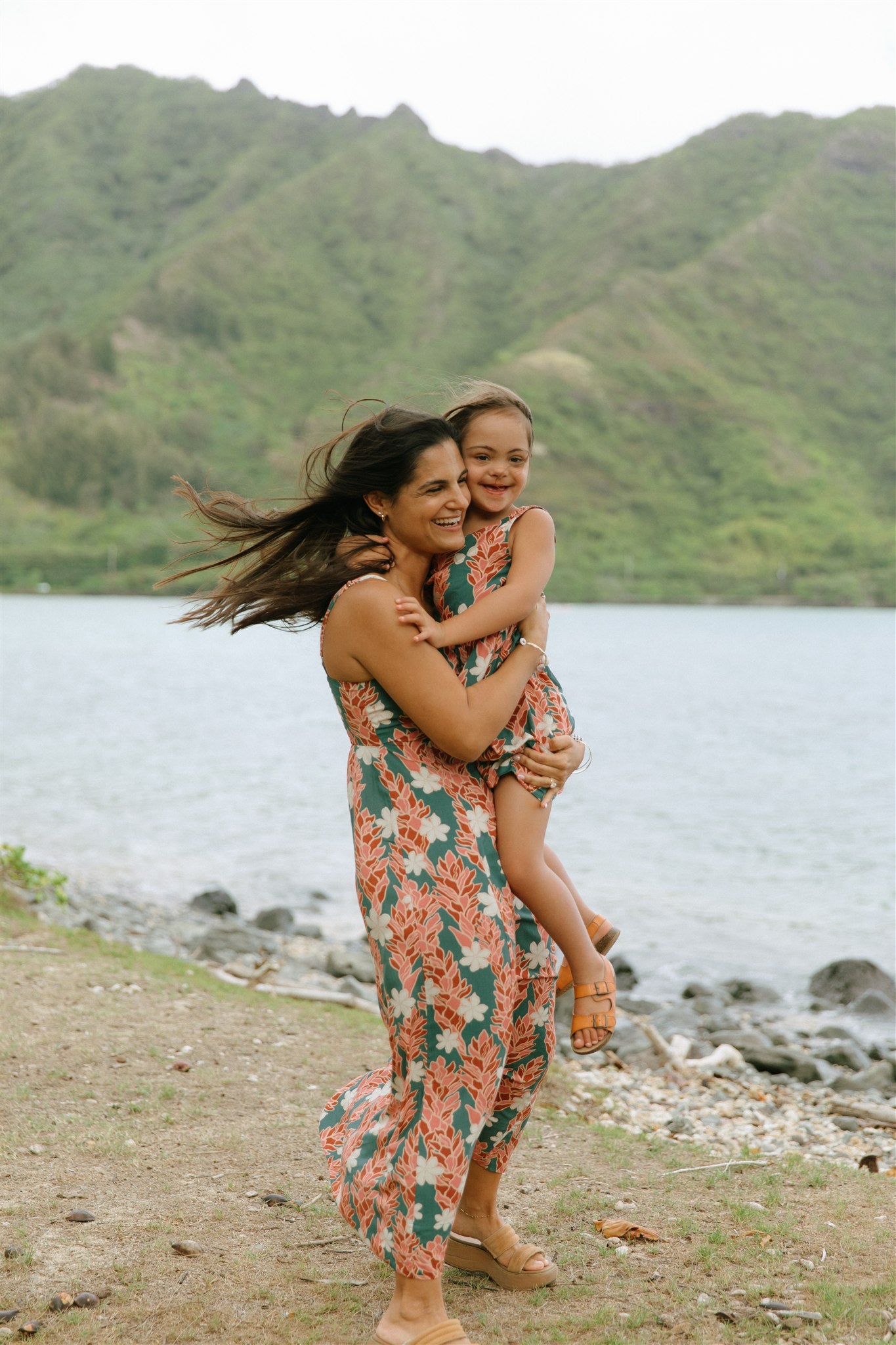 little girl wearing a knee length dress with red ginger and tiare print