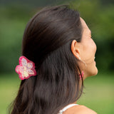 woman wearing a small pink and peach orchid hairclip in hair 