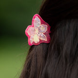 woman wearing a small pink and peach orchid hairclip in hair 