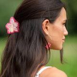 woman wearing a small pink and peach orchid hairclip in hair 