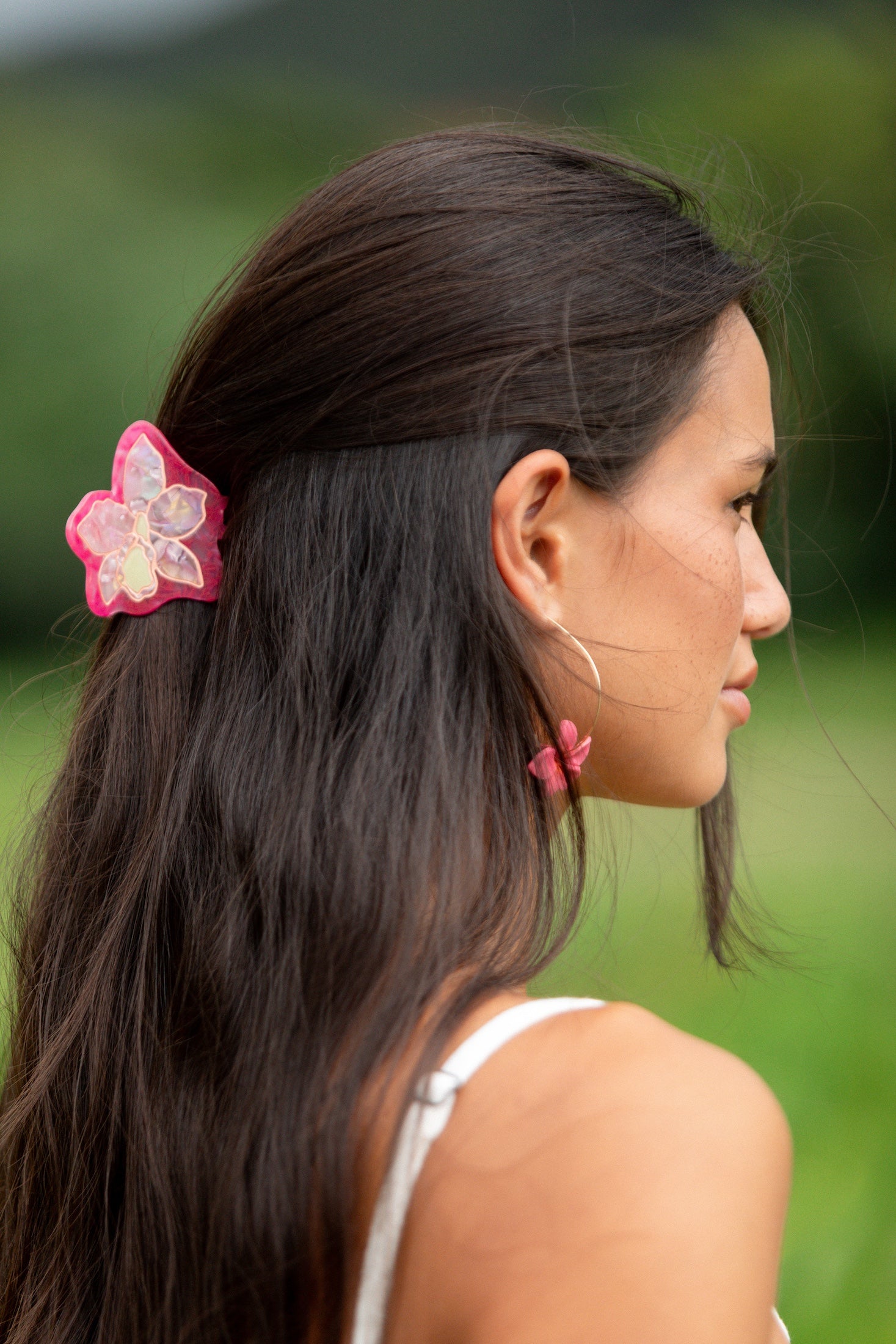 woman wearing a small pink and peach orchid hairclip in hair 