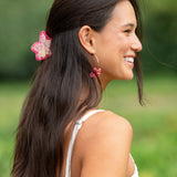 woman wearing a small pink and peach orchid hairclip in hair 